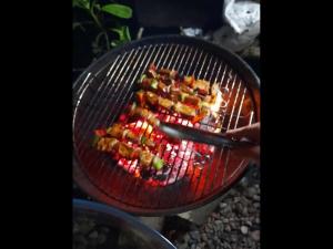 a person is cooking food on a grill at Fare pae tatahi in Afaahiti