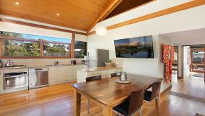 a kitchen with a wooden table and a wooden ceiling at Tea House - The Vintage in Pokolbin