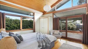 a bedroom with a large bed and a large window at Tea House - The Vintage in Pokolbin