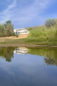 a house on a hill next to a body of water at Beira Rio Casa Canastra in Vargem Bonita +47 photos