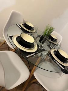 a glass table with hats sitting on top of it at Luxury Apartment in Milton Keynes with Netflix in Broughton +5 photos