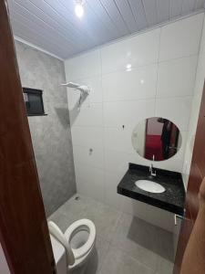 a bathroom with a toilet and a mirror at Flat Mobiliado no centro in Redenção