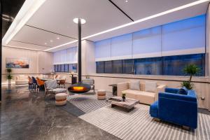 Una sala de estar con un sofá azul y una mesa. en Novotel Hangzhou Xintiandi, en Hangzhou