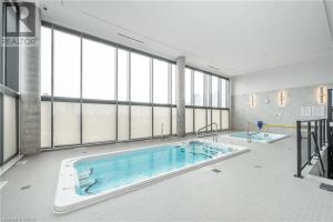 a large swimming pool in a building with windows at Hydropool Spa Hot Tub Bowling Alley Patio BBQ Games in Kitchener