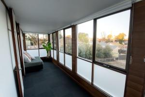a room with large windows with a bed and a plant at Cathedral View - Sleeps 16 in Bendigo