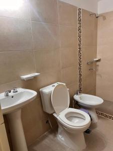 a bathroom with a toilet and a sink at Lihuel AG in Alta Gracia
