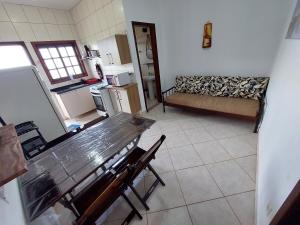 a kitchen with a table and a couch in a room at Flat Refúgio das Bermudas in Ilha Comprida +7 photos