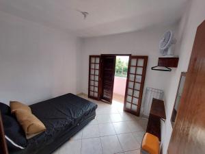 a bedroom with a bed and an open door at Flat Refúgio das Bermudas in Ilha Comprida