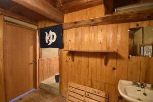 baño con paredes de madera, lavabo y aseo en 庵治みなと番所, en Takamatsu