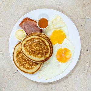 a plate of breakfast food with eggs and sausage at Muna Hotel in San Pedro Sula +22 photos