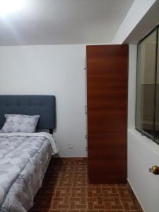 a bedroom with a bed and a wooden door at Huaraz hermoso in Huaraz +18 photos