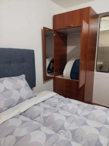a bedroom with a bed and a dresser and mirror at Huaraz hermoso in Huaraz