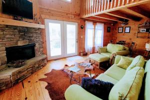 a living room with a couch and a fireplace at Solar powered log cabin with mountain views, 3acres in Lake Lure