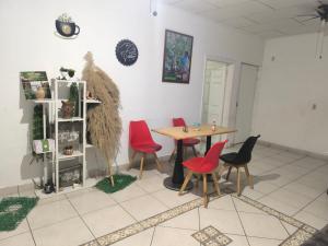 a dining room with a table and red chairs at La casa de don Matilde in San Pedro Sula
