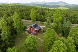 an aerial view of a house in the woods at Solar powered log cabin with mountain views, 3acres in Lake Lure