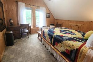 a bedroom with a bed and a table and a window at Solar powered log cabin with mountain views, 3acres in Lake Lure