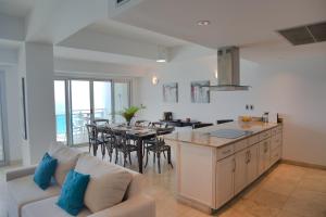 a kitchen and living room with a couch and a table at The Cliff View in Cupecoy