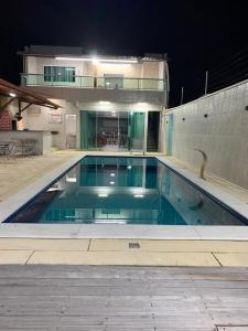 ein Schwimmbad vor einem Gebäude bei Nacht in der Unterkunft Casa Moderna em Nossa Senhora do Ó, Porto de Galinhas! in Ipojuca