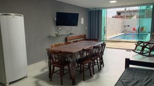 ein Esszimmer mit einem Holztisch und Stühlen in der Unterkunft Casa Moderna em Nossa Senhora do Ó, Porto de Galinhas! in Ipojuca