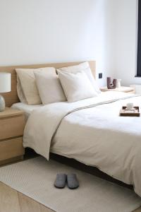 een slaapkamer met een groot bed met witte lakens en kussens bij A Marbled Touched Haven in Antwerpen