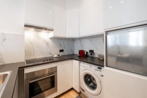 een witte keuken met een wasmachine bij A Marbled Touched Haven in Antwerpen +27 foto's