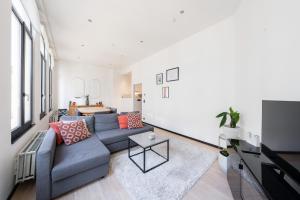 een woonkamer met een bank en een tv bij A Marbled Touched Haven in Antwerpen