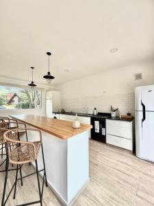 a kitchen with a wooden counter top and a white refrigerator at Casa Don Mario in Villa Ventana