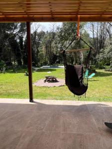 a black hammock hanging from a porch with a park at Casa Don Mario in Villa Ventana