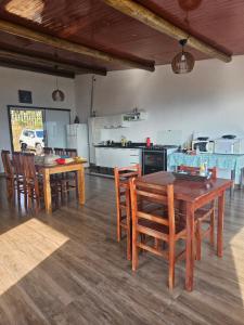 a kitchen and dining room with wooden tables and chairs at Colina da Canastra Pousada in São Roque de Minas
