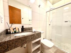 a bathroom with a sink and a toilet and a shower at Casa com 2 quartos, ar-condicionado, Wi-fi e estacionamento in Matinhos +27 photos
