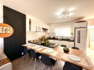 a kitchen with a large wooden table and chairs at Casa com 2 quartos, ar-condicionado, Wi-fi e estacionamento in Matinhos