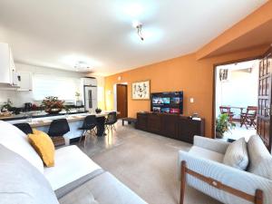 a large living room with a kitchen and a living room at Casa com 2 quartos, ar-condicionado, Wi-fi e estacionamento in Matinhos