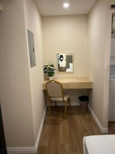 a desk in a room with a chair and a mirror at Tiffany's Suites in Diego Martin
