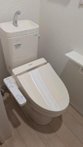a bathroom with a white toilet with a sink at Yomitan 4LDK house in Yomitan +8 photos