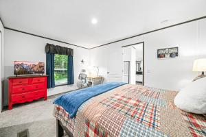 a bedroom with a bed and a red dresser at Bon Air Bungalow in Sparta