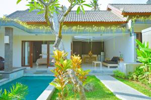 a villa with a swimming pool in front of a house at Villa Padma Ubud in Ubud