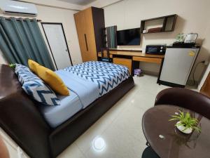 a bedroom with a bed and a desk and a television at 66 Apartment in Ban Khlong Nong Yai