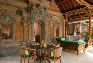 una sala de estar con una mesa y un sofá en Honeymoon Guesthouse, en Ubud