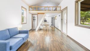 a living room with a blue couch and a staircase at Gapyeong Daon Dokchae Pension in Gapyeong +5 photos