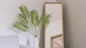 a plant in a white vase in front of a mirror at Gapyeong Daon Dokchae Pension in Gapyeong