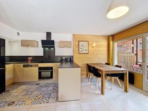 拉克吕萨La Clusaz : Appart cosy, 6 pers, parking inclus - FR-1-818-110的带桌子的厨房和餐厅
