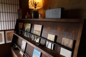 a shelf with books and a light on a wall at 名場越庵 -Nabakoshian- in Karatsu +18 photos