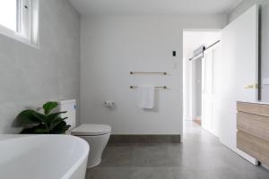 Un baño blanco con bañera y inodoro. en South Launceston Gem, Minutes to Cataract Gorge, en Kings Park 22 fotos más