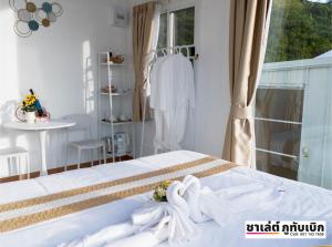 een slaapkamer met een bed met witte handdoeken bij ชาเลต์ ภูทับเบิก in Ban Maeo Thap Boek