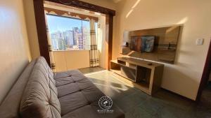 TV a/nebo společenská místnost v ubytování Apto central em Torres - Apenas 250 mts do mar - Ar condicionado - TV Smart - Wifi - Roupa de cama e Banho - Garagem - Cozinho completa - Aceita Pet