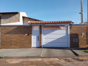 a garage with a white door and a tile roof at Casa Alice e Matheus in Olímpia