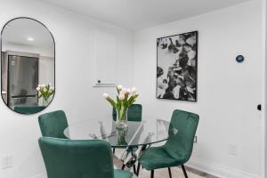 a dining room with a glass table and green chairs at Modern 1-BR Condo with Parking in Downtown Toronto in Toronto