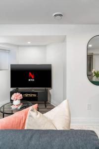 a living room with a tv and a couch at Modern 1-BR Condo with Parking in Downtown Toronto in Toronto +15 photos