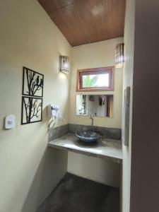 une salle de bain avec un lavabo et une fenêtre dans l'établissement Há Mar Chalés Corumbau, à Prado