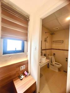 un baño con inodoro y lavabo en Salux Hotel, en Da Nang